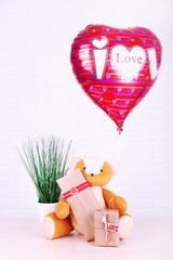 Obraz na płótnie Canvas Teddy bear with present boxes, plant and love heart balloon