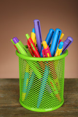 Colorful pens in green metal holder