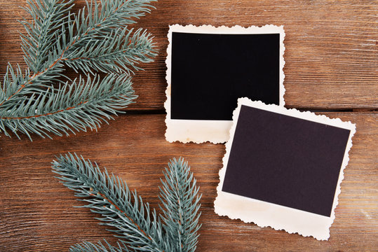 Blank photo frames and fir tree on wooden table background