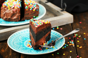 Chocolate cake with colorful sweet powder on table close-up
