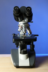 Fototapeta na wymiar Microscope on table, on color background