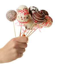 Female hand holding cake pops, isolated on white