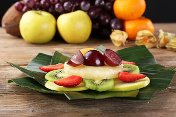 Fototapeta na wymiar Fruit dessert on green leaf on table