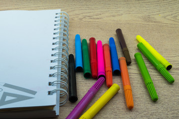 Obraz premium Book and magic color pen on the wooden.