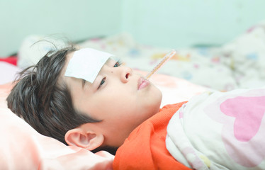 Little sick boy with temperature in mouth