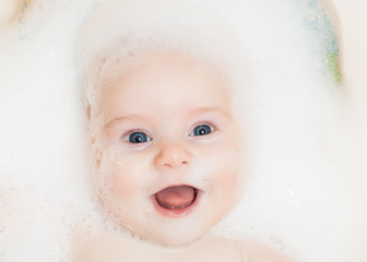 Chest baby boy bathing in a bath with foam on head