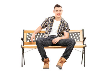 Fototapeta na wymiar Cool young male model sitting on a bench