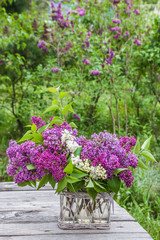 Bouquet of lilac on the table in the garden