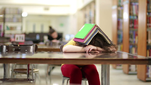 Girl Buried Under Book Stack