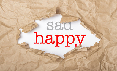Happy and sad words on paper and torn cardbox