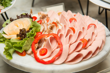 Platter of assorted cold cut slices.