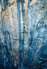 Rock climber climbing up a cliff