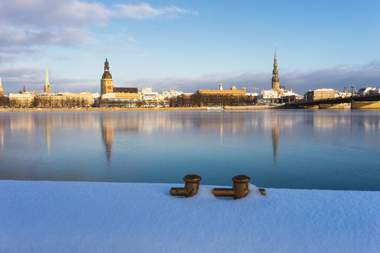 Panorama of Riga with reflection in a frozen river and gold bert