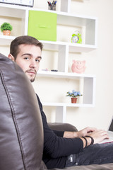 Obraz premium Guy using computer sitting on sofa