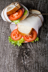sandwich bandaged twine on a textured wooden board. tinted