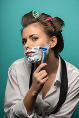 Cute brunette woman in hair curlers posing with foam on face sha