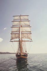 old historical ship (yacht) with white sails, sailing in the sea