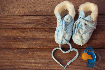 Fototapeta na wymiar heart symbol is drawn laces of children's shoes and a pacifier