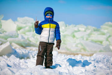 Fototapeta na wymiar Cute little boy outdoors standing on winter beach