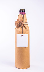 bottle wrapped in paper with decorative flower and clean blank