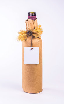 bottle wrapped in paper decorative bow and blank card