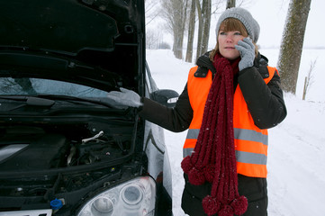Junge Frau mit Autopanne im Winter