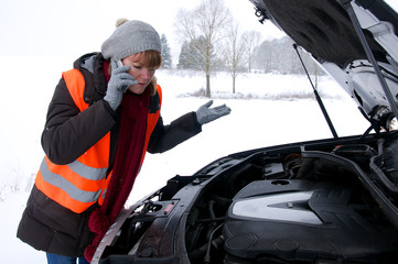 Junge Frau mit Autopanne im Winter