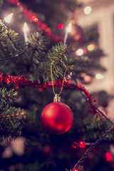 Retro image of Christmas tree decorated with traditional ornamen