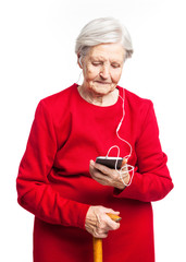 Senior woman holding smartphone and listening to music