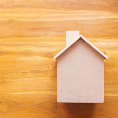 Obraz na płótnie Canvas small wood house model on brown wooden background