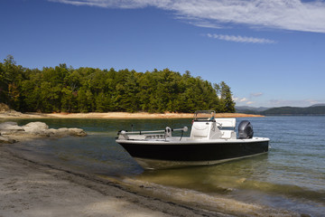 Fototapeta na wymiar Fishing boat on the shore by a lake.