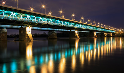 Highlighted bridge at night and reflected in the water.Bridge Gd