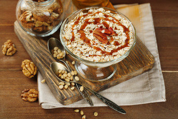 Tasty dessert with oat flakes and honey, on table
