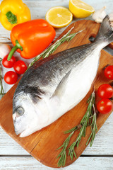 Fresh raw fish and food ingredients on table