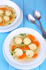 Soup with meatballs and noodles in bowls