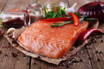 Fresh salmon with spices on wooden table