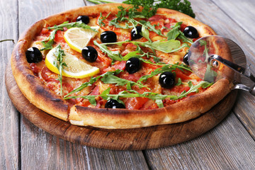 Tasty pizza with herbs and round knife