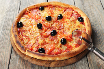 Tasty pizza with black olives and round knife