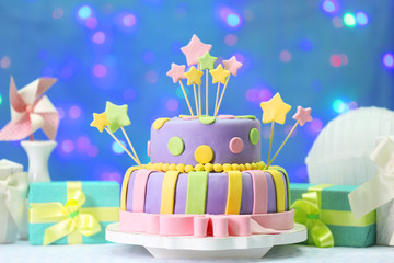 Delicious birthday cake on shiny blue background