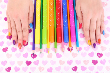 Multicolor female manicure with markers and pencils