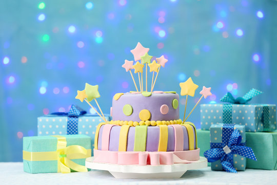 Delicious birthday cake on shiny blue background