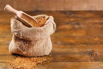 Mustard seeds in bag on  wooden background