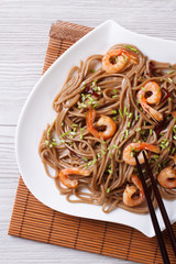 soba noodles with shrimp on a plate close-up. vertical
