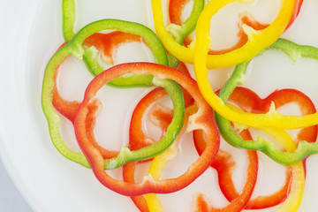 Arrangement of sliced bell peppers on white background