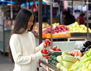 Beautiful young woman smiling at the vegetable market
