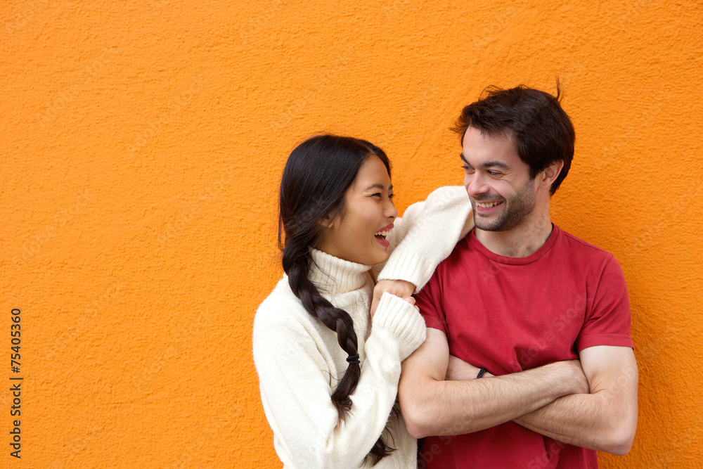 Wall mural two happy friends laughing against orange background