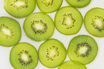 Naklejka na ściany i meble Arranged fresh Kiwi fruit sliced for healthy presentation background. Kiwi contain a lot of Vitamin C protect from Virus