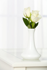 Beautiful bouquet of flowers in vase on window background