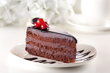 Delicious chocolate cake on plate on table on light background