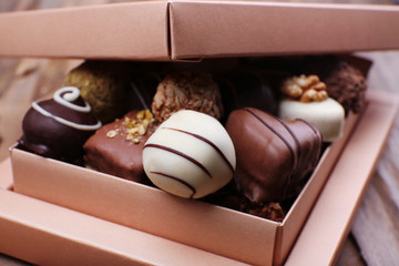 Box filled with chocolates on wooden rustic background